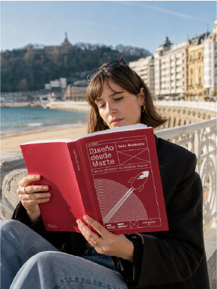Mujer leyendo el libro Diseño desde Marte en el paseo de San Sebastián con la bahía al fondo