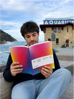 Chico leyendo el libro La paleta perfecta frente al Aquarium de San Sebastián