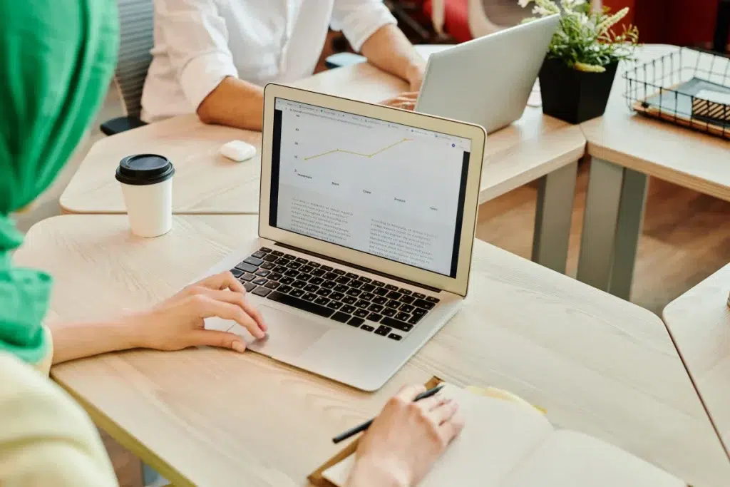 Profesionales analizando datos en un portátil para evaluar el rendimiento de contenidos digitales