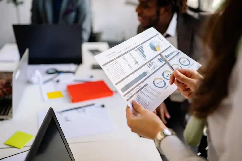 Profesionales revisando gráficos y documentos durante un análisis de información en equipo