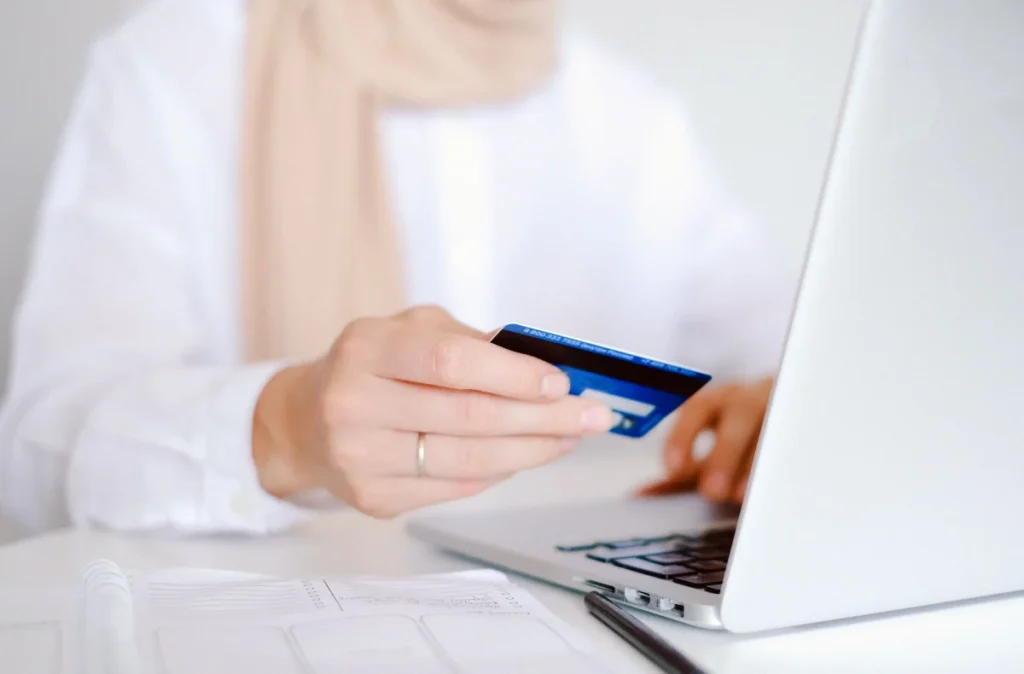 Persona realizando una compra online con tarjeta y portátil para ilustrar el pago con Stripe en WooCommerce