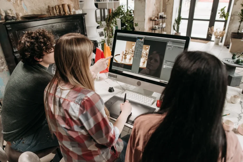 Equipo creativo trabajando frente a un ordenador para ilustrar el uso de plantillas WordPress premium en agencias y portfolios
