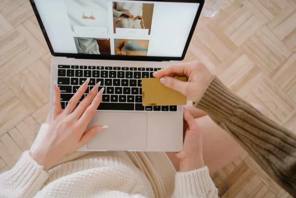 Persona comprando online con portátil y tarjeta para ilustrar plugins WooCommerce de checkout, Stripe y Redsys
