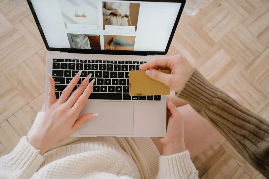 Persona comprando online con portátil y tarjeta para ilustrar una comparativa entre Shopify y WooCommerce