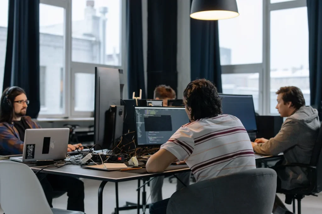 Equipo de desarrolladores revisando ordenadores para ilustrar pruebas en staging antes de actualizar PHP en WordPress