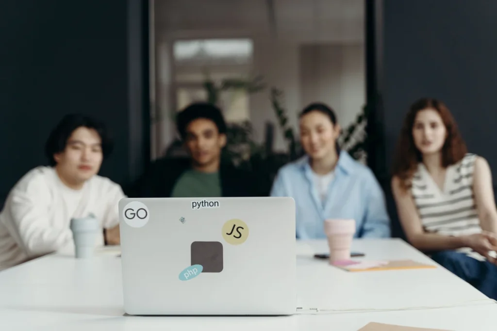 Equipo revisando un proyecto en un portátil para ilustrar validación, testing y revisión humana del código generado con IA